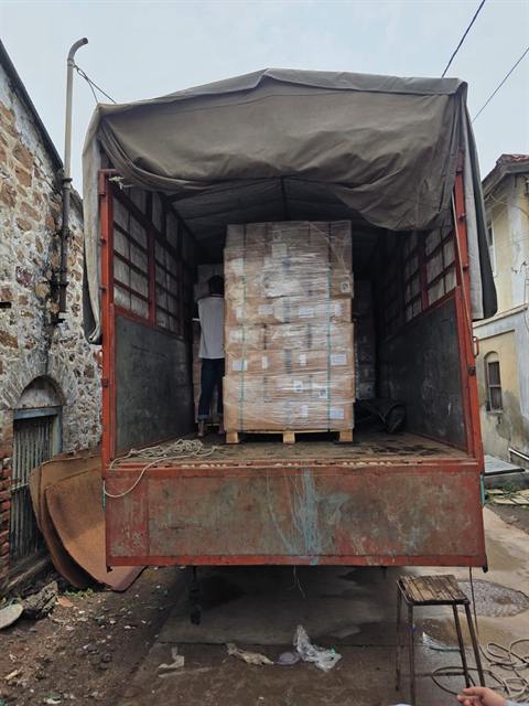 Palletised, stretch-wrapped export cargo being loaded onto a truck